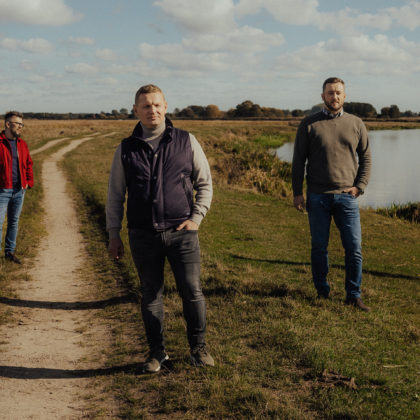 Skłodowscy. Na zdjęciu czterech mężczyzn stoją na polu blisko rzeki.